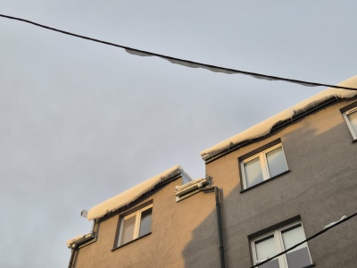 Uwaga na niebezpieczne nawisy śnieżne. Z dachów w Krakowie spada śnieg i lód