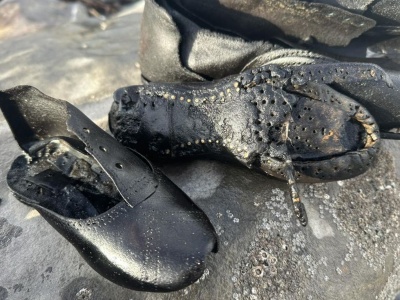 Setki butów wypłynęły na plaży w Walii i zapoczątkowały wielką zagadkę. Nie przypominają współczesnych modeli