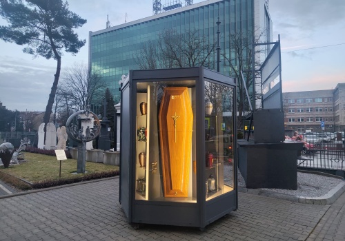 Trumnomat w Krakowie. W przeszklonej gablocie obracają się trumny i urny