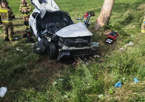 Poważne zderzenie dwóch aut. Peugeot uderzył w drzewo. Trzy osoby ciężko ranne. Droga zablokowana