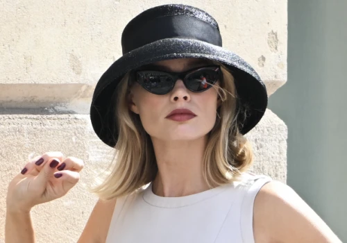 Margot Robbie zachwyca jako luksusowa kryminalistka. Jej biała mini sukienka i czarny kapelusz mają szansę na status „it”?