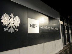 Prokurator i policjanci weszli do siedziby NBP. W tle dokumenty dotyczące RPP