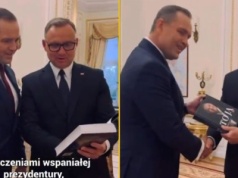 Prezydent promuje książkę i wręcza ją Nawrockiemu. 