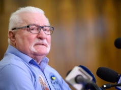 Daleko od Polski, ale blisko ludzi. Wałęsa w koszuli z napisem „Konstytucja” i orłem.