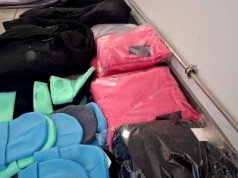 Odzież z podrobionymi znakami towarowymi w rękach policjantów