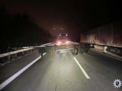 Naczepa podkontenerowa porzucona na autostradzie, w nocy, w poprzek jezdni