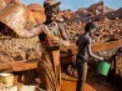 Tu kobiety kopią złoto z niemowlętami przy biodrze