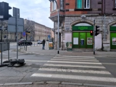 Droga zamknięta, ale piesi stoją i czekają na zielone. Samochodów prawie nie ma